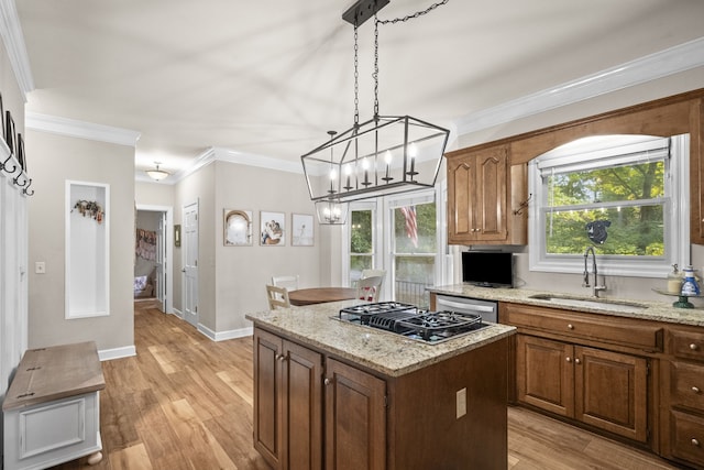 kitchen featuring a chandelier, light hardwood / wood-style floors, a center island, sink, and ornamental molding