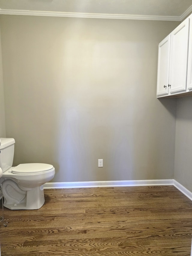 bathroom with crown molding, hardwood / wood-style flooring, and toilet