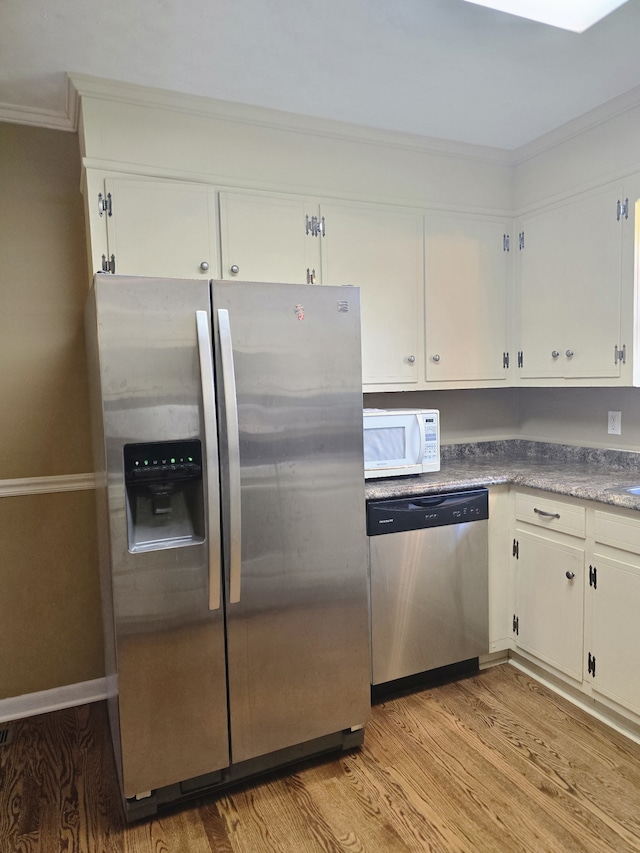 kitchen with crown molding, light hardwood / wood-style flooring, stainless steel appliances, and white cabinets