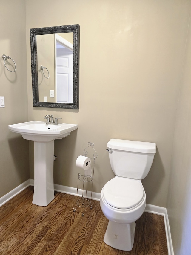 bathroom featuring hardwood / wood-style flooring and toilet