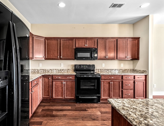 kitchen featuring black appliances, dark hardwood / wood-style floors, and light stone counters