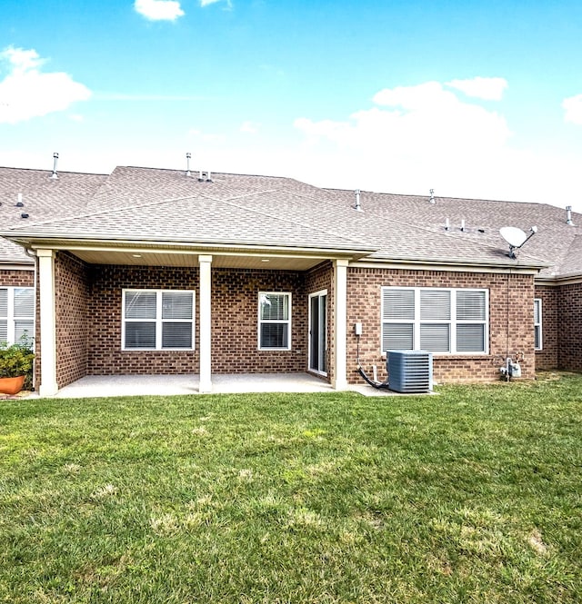 rear view of property featuring a lawn, a patio, and central AC