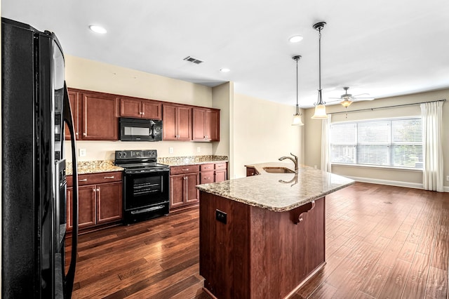 kitchen with ceiling fan, a center island with sink, dark hardwood / wood-style flooring, and black appliances