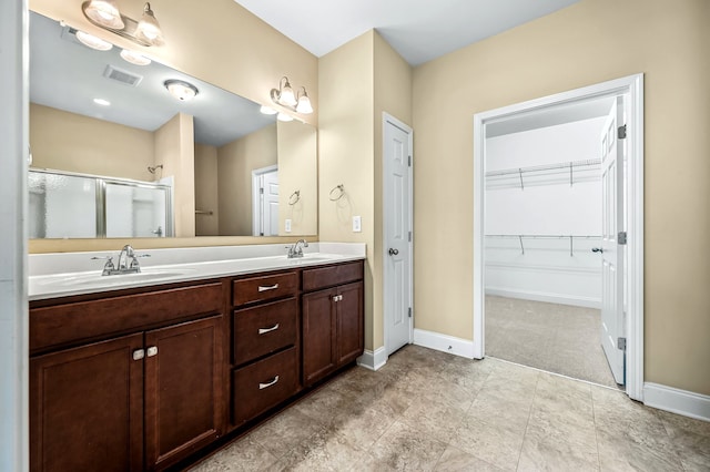 bathroom with vanity and a shower with shower door