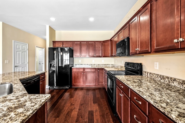 kitchen featuring light stone countertops, black appliances, and dark hardwood / wood-style floors