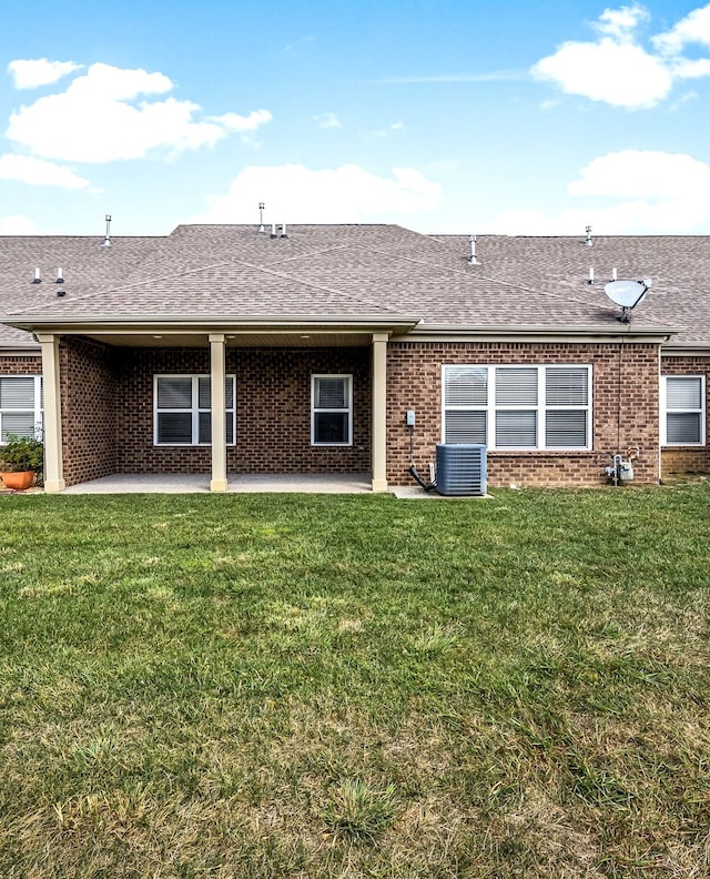 rear view of property featuring central AC unit, a lawn, and a patio