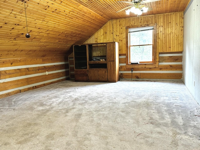bonus room featuring vaulted ceiling, carpet, a ceiling fan, wood walls, and wood ceiling
