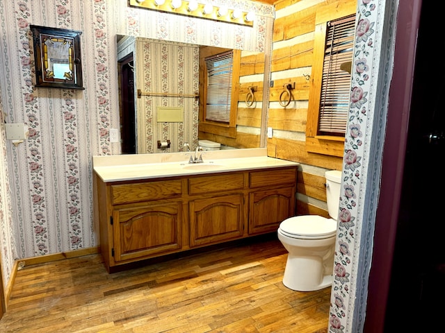 bathroom with vanity, wood walls, toilet, and wood-type flooring