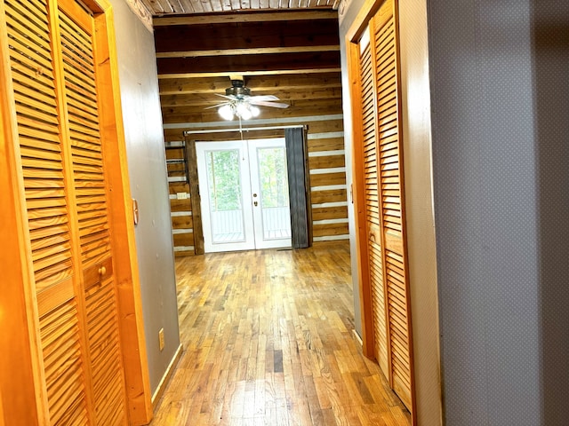 corridor with french doors and light hardwood / wood-style flooring