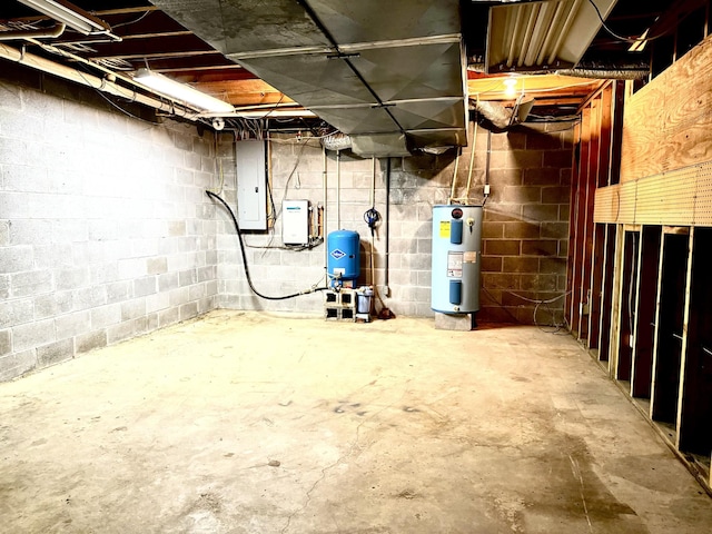unfinished basement with electric panel, water heater, and concrete block wall