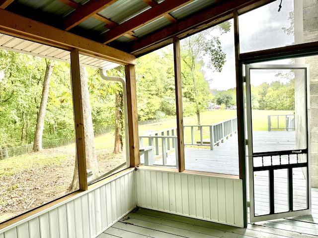 unfurnished sunroom featuring plenty of natural light and beamed ceiling