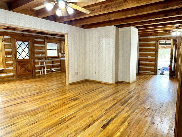 unfurnished living room featuring beamed ceiling, hardwood / wood-style floors, and ceiling fan