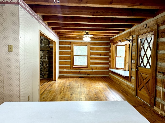 spare room with ceiling fan, hardwood / wood-style floors, and beamed ceiling