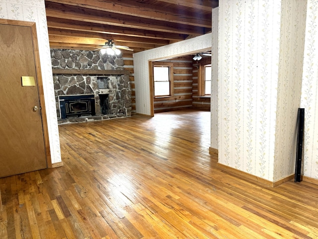 unfurnished living room featuring ceiling fan, beamed ceiling, and wood-type flooring