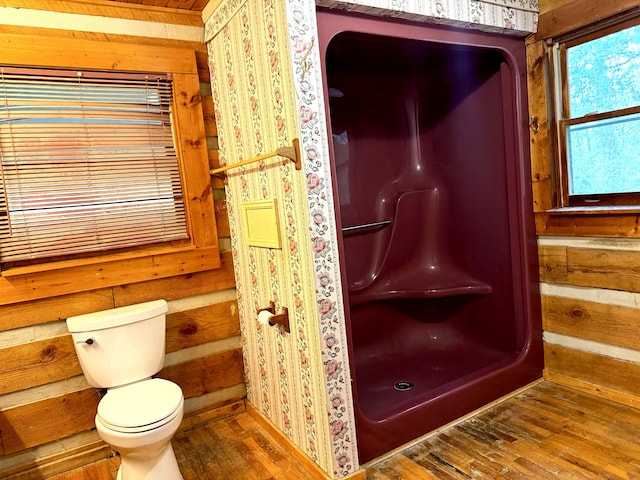 bathroom featuring wood walls, wood-type flooring, and toilet