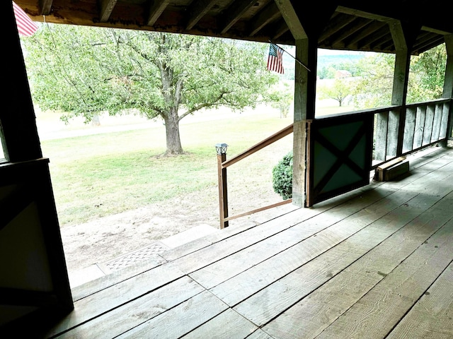 wooden terrace featuring a lawn