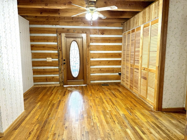 foyer entrance with wallpapered walls, hardwood / wood-style flooring, and ceiling fan
