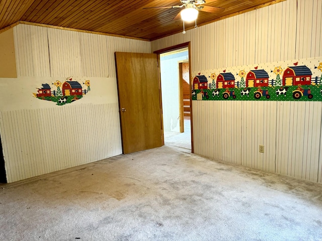 empty room featuring carpet floors, a ceiling fan, and wooden ceiling