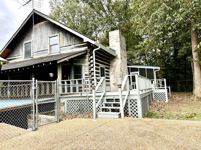 exterior space featuring a wooden deck and a sunroom