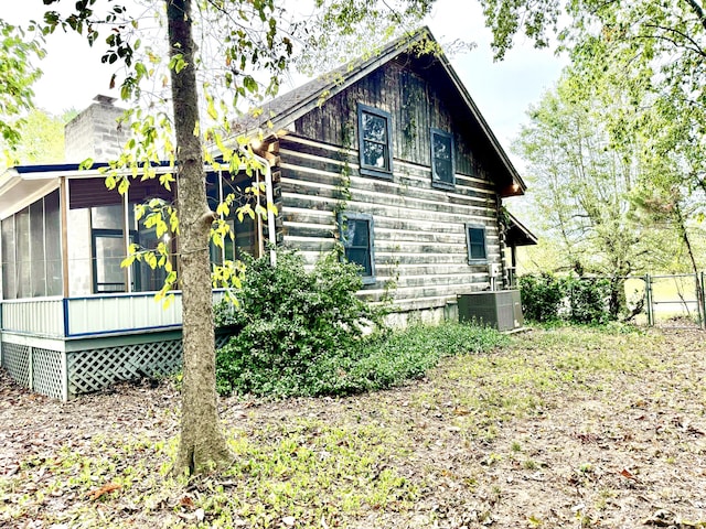 view of side of property with central AC unit and a sunroom