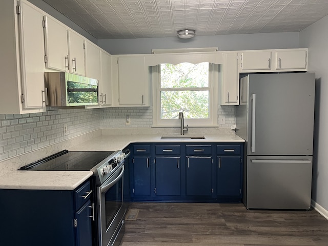 kitchen with blue cabinets, appliances with stainless steel finishes, sink, and white cabinetry