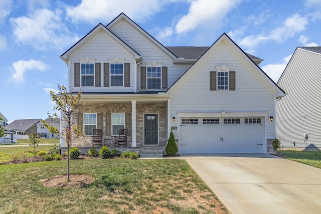 view of front of home featuring a front lawn, covered porch, and a garage