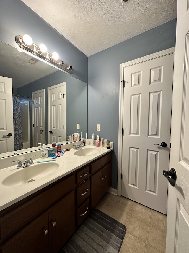 bathroom featuring vanity, tile patterned flooring, a textured ceiling, and curtained shower