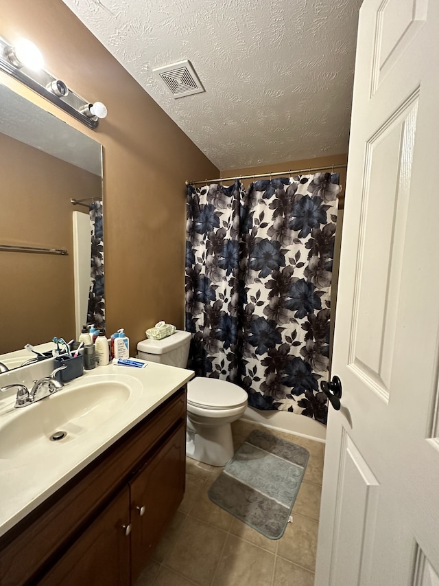 full bathroom featuring tile patterned flooring, a textured ceiling, shower / tub combo with curtain, vanity, and toilet