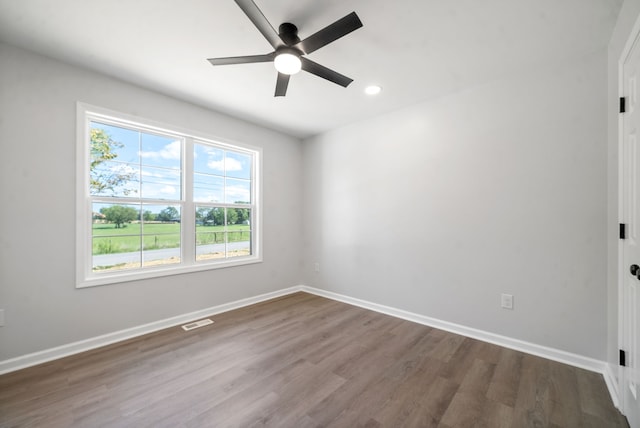 spare room with dark hardwood / wood-style floors and ceiling fan