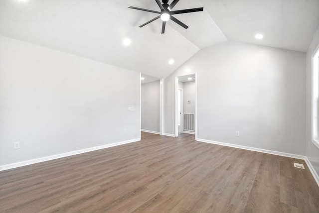 empty room with ceiling fan, lofted ceiling, and hardwood / wood-style floors