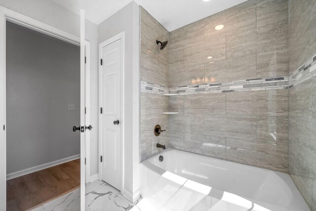 bathroom featuring wood-type flooring and tiled shower / bath combo