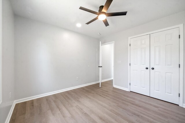 unfurnished bedroom with ceiling fan, a closet, and light hardwood / wood-style floors