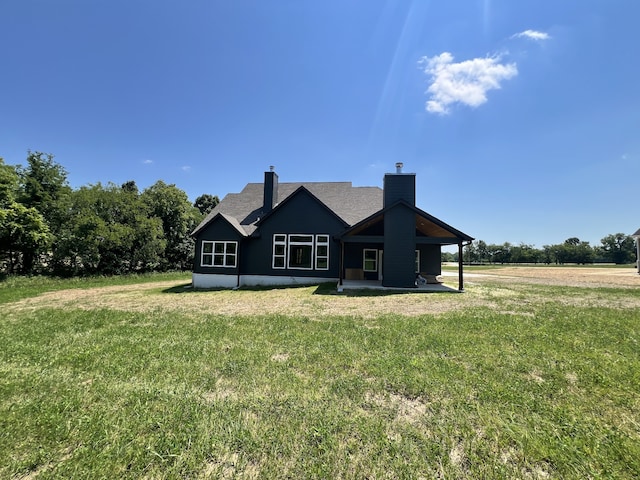 rear view of house with a lawn and a rural view