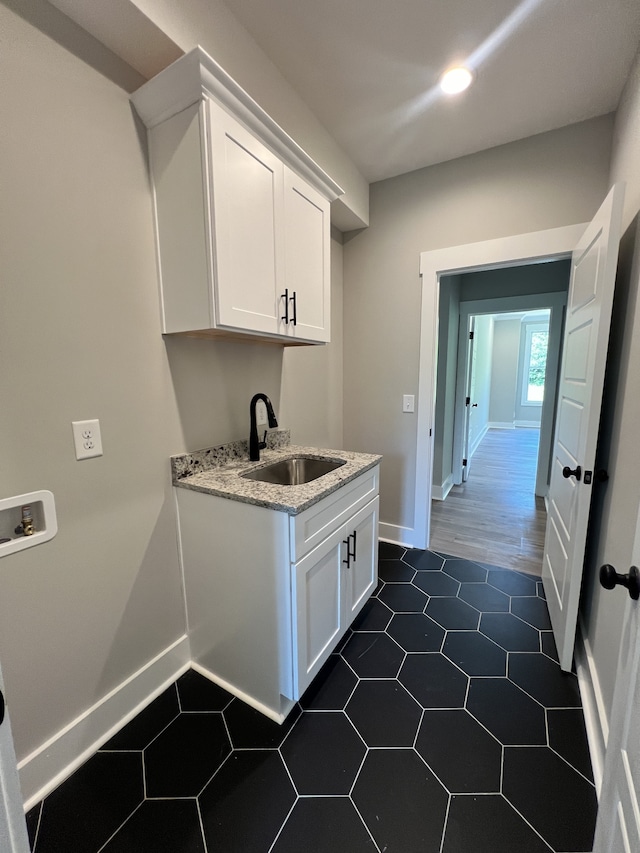 washroom with washer hookup, cabinets, dark wood-type flooring, and sink