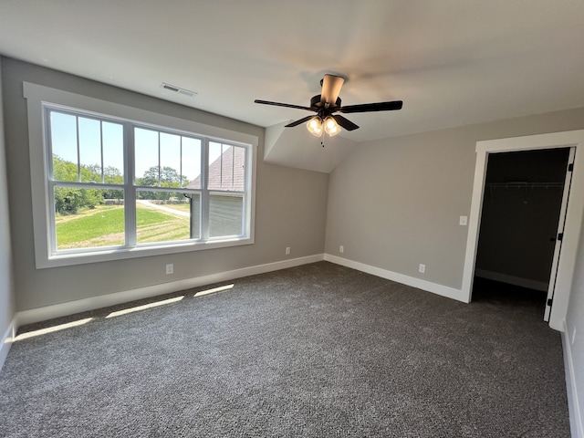 unfurnished room featuring dark colored carpet, lofted ceiling, and ceiling fan