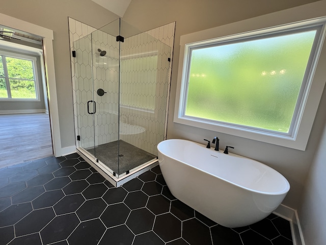 bathroom featuring separate shower and tub, tile patterned flooring, and a wealth of natural light