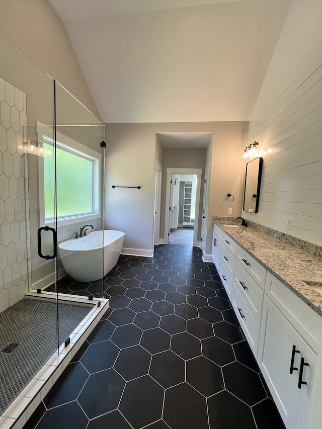 bathroom featuring independent shower and bath, tile patterned flooring, vaulted ceiling, and vanity