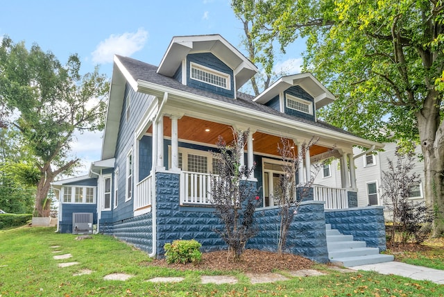 view of front of house with a front yard, a porch, and central air condition unit