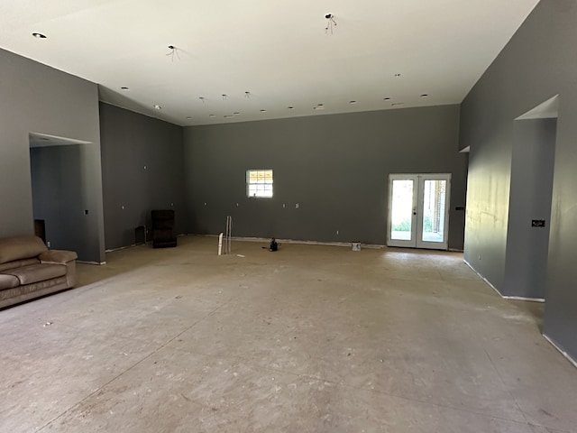 unfurnished room with a towering ceiling and french doors