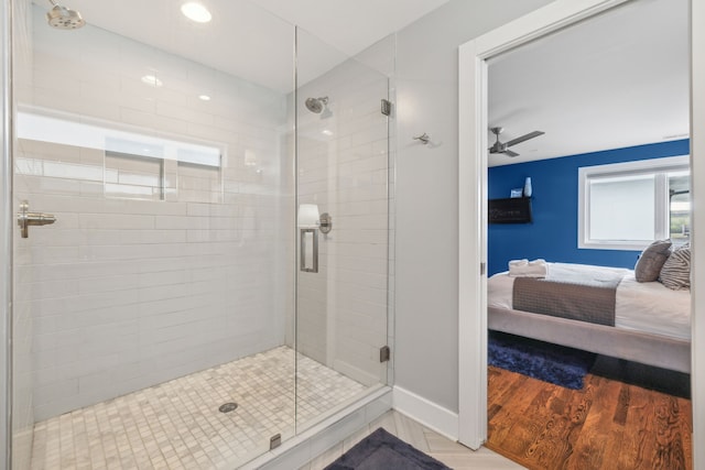 bathroom with wood-type flooring, ceiling fan, and a shower with shower door