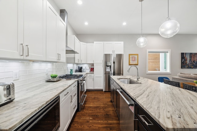 kitchen featuring hanging light fixtures, white cabinets, stainless steel appliances, dark hardwood / wood-style floors, and sink