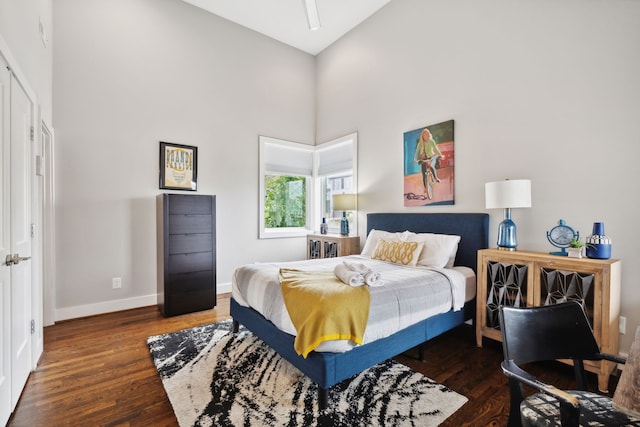 bedroom featuring dark hardwood / wood-style flooring and high vaulted ceiling