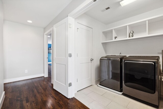 laundry area with washer and clothes dryer and hardwood / wood-style floors