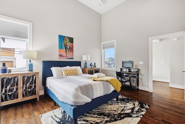 bedroom with dark hardwood / wood-style floors and high vaulted ceiling