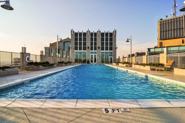 pool with a patio and fence