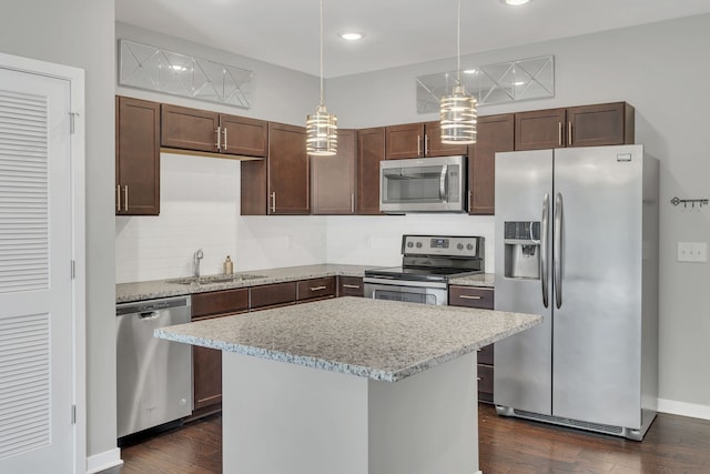 kitchen featuring decorative light fixtures, appliances with stainless steel finishes, dark wood-type flooring, and sink