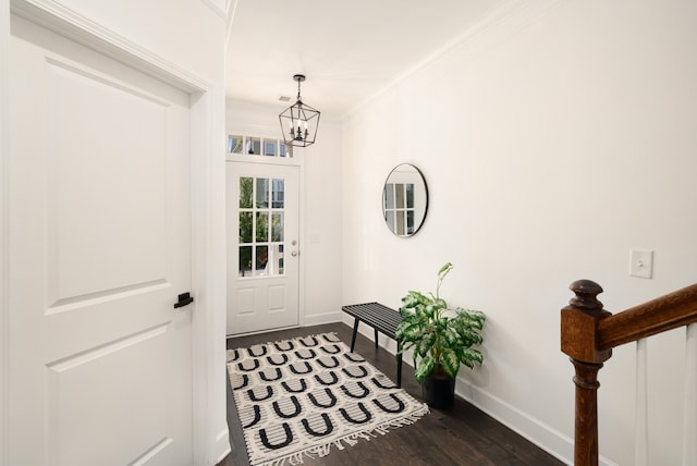 doorway featuring a notable chandelier, crown molding, and dark hardwood / wood-style flooring