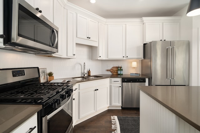 kitchen with white cabinetry, appliances with stainless steel finishes, dark hardwood / wood-style floors, and sink