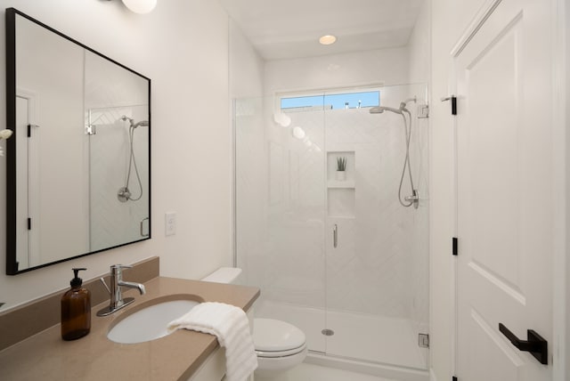 bathroom with walk in shower, vanity, and toilet