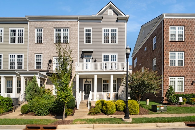 view of property featuring a balcony and a porch